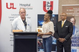 Gunshot wound survivor Sheronda Morris Jasper presents the Endless Stairway Award to trauma surgeon Brian Harbrecht, MD