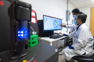 Kavitha Yaddanapuddi, Ph.D., (left) and Chuanlin Ding, Ph.D., use a mass cytometer to help improve the effectiveness of cancer immunotherapies.