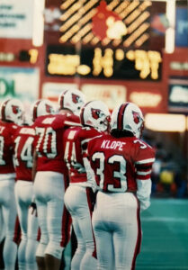 Kathryn Klope vanTonder stands alongside several teammates at a football game in the old Cardinal Stadium.