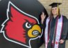 Marine Corps Veteran and mom of three keeps a promise to herself as a UofL graduate Christel Blocker stands in front of a Cardinal head in her cap and gown.