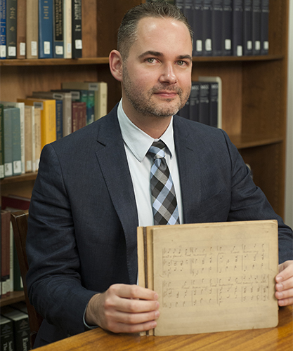 James Procell holds Hill's manuscript, found recently at UofL.