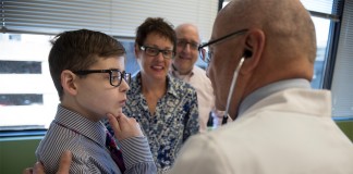 Salvatore Bertolone Jr., M.D., talks with 16-year-old patient Noah Barone during a recent clinic visit as parents Michael and Geneva Barone look on.
