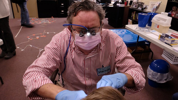 Dr. Charles Tritle conducts oral health screenings at Bullitt Lick Middle School.