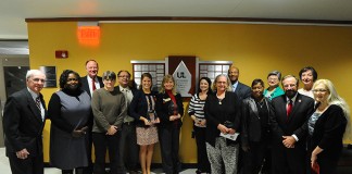 Winners of the 2014 Outstanding Community Engagement Awards surround the plaque in the lower level of Ekstrom Library that bears the names of the winners. Photo by Tom Fougerousse.