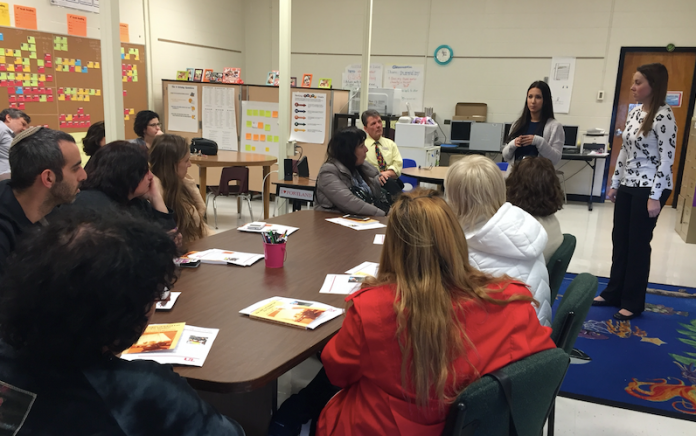 UofL student teachers (standing left to right) Micaela Wang and Brittany Bennison share information about UofL’s CEHD teacher education program and answer questions during the April 12 visit by teachers from Israel.