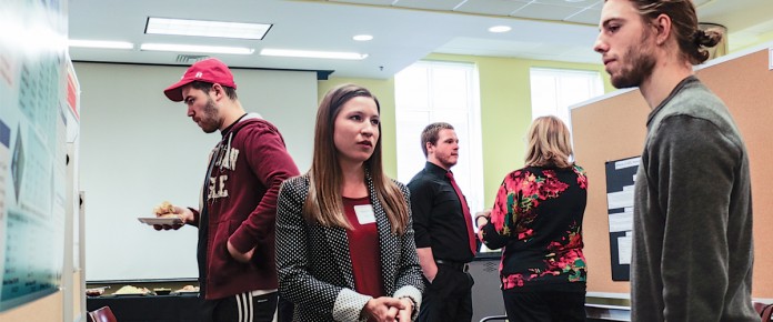 UofL student Elizabeth Kloenne explains her undergraduate research project to the UofL community.