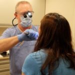 David C. Jones, DMD, lecturer at the School of Dentistry, performs an oral exam on a patient in the North American Mission Board's mobile clinic on May 20.