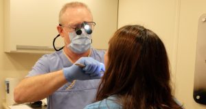 David C. Jones, DMD, lecturer at the School of Dentistry, performs an oral exam on a patient in the North American Mission Board's mobile clinic on May 20.
