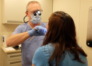 David C. Jones, DMD, lecturer at the School of Dentistry, performs an oral exam on a patient in the North American Mission Board's mobile clinic on May 20.