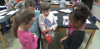 Lucas Abraham, who was born without fingers on his right hand, shows classmates his 'robo-hand.'