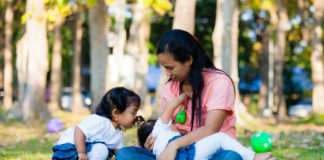 Young mother feeding her baby in the park.