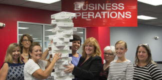 UofL's Business Operations team shows off how much paper was saved during the shared services soft launch.