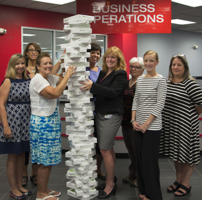 UofL's Business Operations team shows off how much paper was saved during the shared services soft launch.