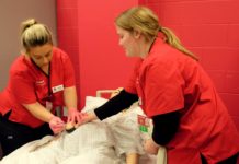 UofL School of Nursing students Abigail Babbitt, left, and Courtney Albers practice administering medications on a patient simulation mannequin in the lab that will be renovated courtesy of $250,000 in donations from The Bufford Family Foundation and Trilogy Health Services.