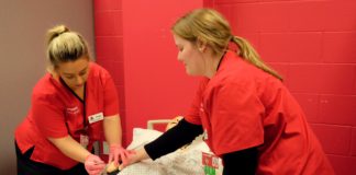 UofL School of Nursing students Abigail Babbitt, left, and Courtney Albers practice administering medications on a patient simulation mannequin in the lab that will be renovated courtesy of $250,000 in donations from The Bufford Family Foundation and Trilogy Health Services.