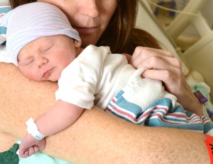 newborn with mom in hospital bed