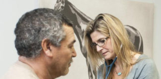 A nurse practitioner, right, treats a patient at the Kentucky Racing Health Services Center.