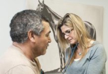 A nurse practitioner, right, treats a patient at the Kentucky Racing Health Services Center.