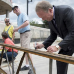 A "top off" ceremony marked a construction milestone for the four-story,150,000-square-foot Belknap Academic Building, which is on track to open fall 2018. President Greg Postel signed one of the beam before it was placed.