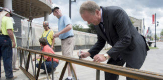 A "top off" ceremony marked a construction milestone for the four-story,150,000-square-foot Belknap Academic Building, which is on track to open fall 2018. President Greg Postel signed one of the beam before it was placed.