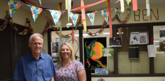 Ben King and his former student assistant Stacey Alvie stand in King’s decorated office in Ekstrom Library.