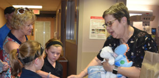 Pauline Hayes, right, NICU manager, accepts blankets and stuffed animals from Madelyn and Shelby Medley on behalf of the UofL Center for Women & Infants.
