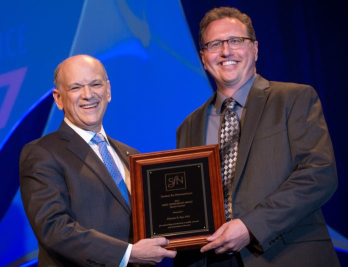 Kristopher K. Rau, Ph.D., receives the Next Generation award from Eric Nestler, M.D., Ph.D., 2016-17 president of the national Society for Neuroscience.