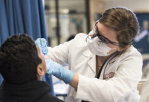 UofL dental student provides screening for a child.