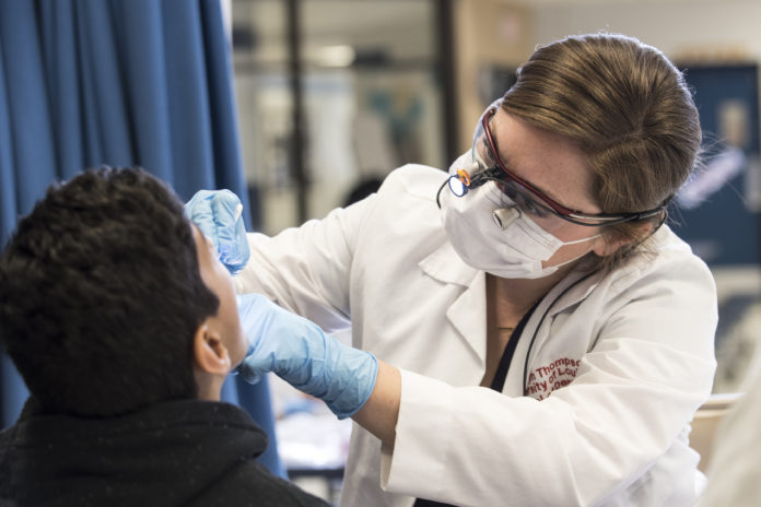 UofL dental student provides screening for a child.