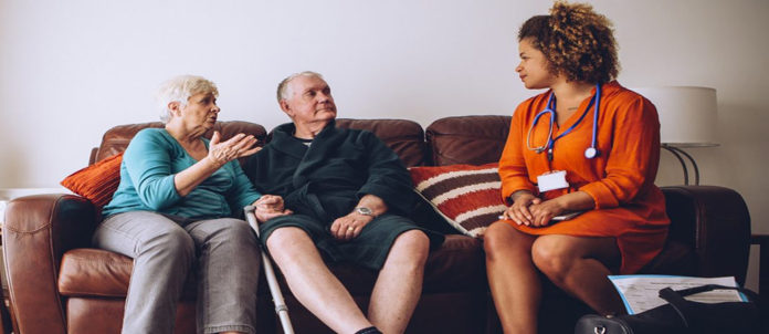 Elderly Couple with Home Carer Older adults talking with a health care provider.