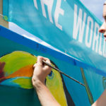 An artist paints the Forecastle Foundation mural during the Forecastle Festival.