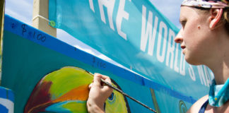 An artist paints the Forecastle Foundation mural during the Forecastle Festival.
