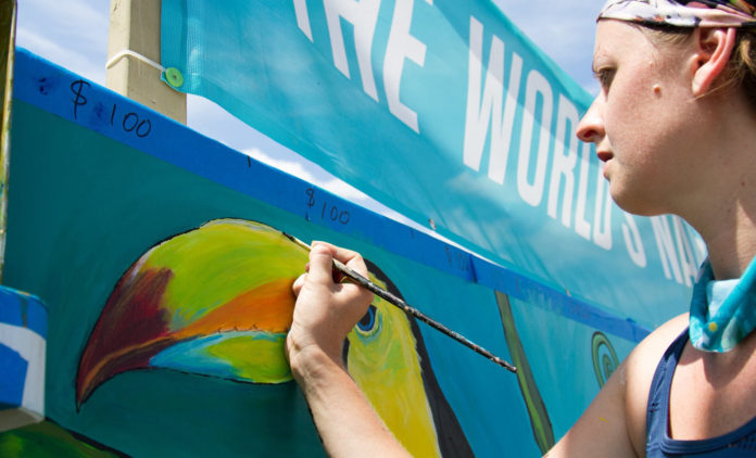 An artist paints the Forecastle Foundation mural during the Forecastle Festival.