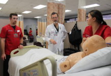 Paul Clark, center, guides UofL School of Nursing students during a clinical simulation.