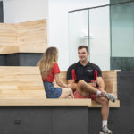 UofL students hang out on the first-floor benches of the Belknap Academic Building. Those benches are made from wood recycled from Crawford Gym, which once stood on the very same site.