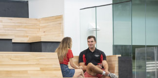 UofL students hang out on the first-floor benches of the Belknap Academic Building. Those benches are made from wood recycled from Crawford Gym, which once stood on the very same site.