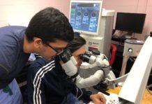 Ophthalmology residents Sidharth Puri, M.D., standing, and Mohammad Ali Sadiq M.D., training in cataract eye surgery using artificial eyes in a ‘wet lab’ at the University of Louisville