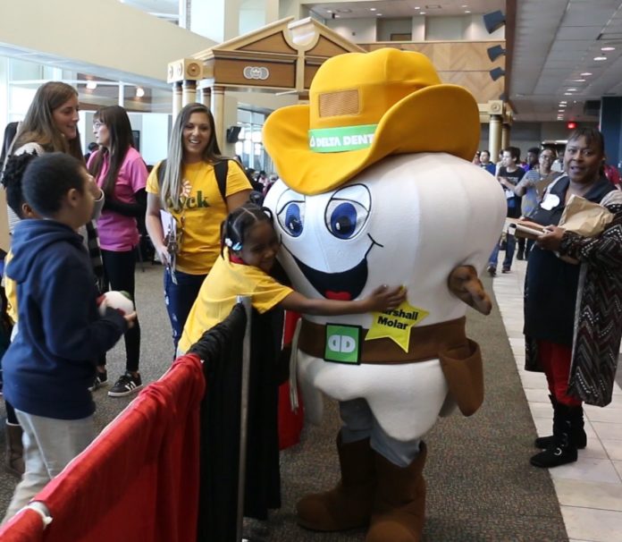 A student embraces Marshall Molar at MedFest