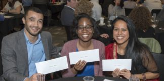 Three medical students hold their envelopes on Match Day.