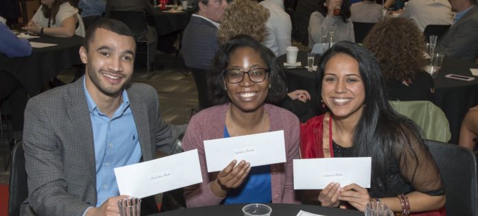 Three medical students hold their envelopes on Match Day.