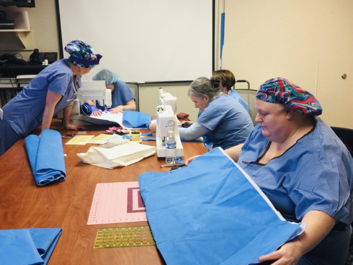 UofL Hospital employees making pillows, sleeping bags and totes from sterile wraps to be distributed at Wayside Christian Mission.