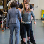 Claudia Angeli and Katie Pfost assist Kelly Thomas use a walker in the KSCIRC lab in Frazier Rehab Institute.