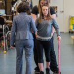 Claudia Angeli and Katie Pfost assist Kelly Thomas use a walker in the KSCIRC lab in Frazier Rehab Institute.