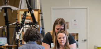 Claudia Angeli and Katie Pfost assist Kelly Thomas use a walker in the KSCIRC lab in Frazier Rehab Institute.