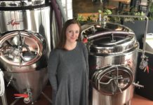 Becky Steele stands in front of equipment at False Idols Brewery.
