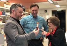 UofL's Marty O'Toole, Qualigen CEO Michael Poirier and UofL's Paula Bates in a lab examining a test tube