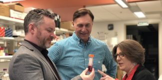 UofL's Marty O'Toole, Qualigen CEO Michael Poirier and UofL's Paula Bates in a lab examining a test tube