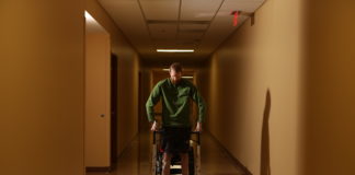 Spinal cord therapy research participant Jeff Marquis stands during therapy. Photo by Jessica Ebelhar.