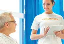 Teen volunteering to help a patient in a health care setting.