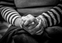 Older adult with hands folded